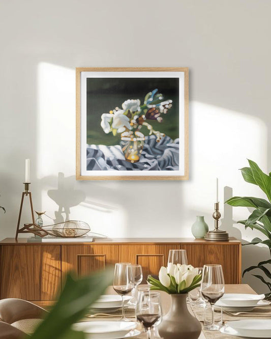 Dining room with a framed blurry bokeh still life fine art print on the wall, table set with plates and glasses, and plants.