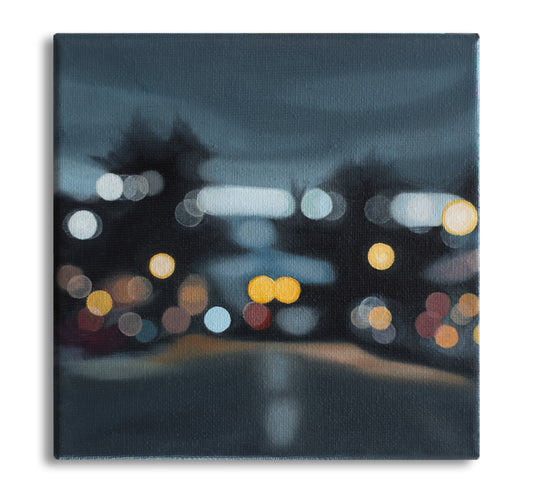 Wanaka New Zealand, Helmore street view towards lake. Painted in a blurry bokeh style on a small canvas framed in wood frame. Lights of the street and cars. Art by New Zealand artist Mel McKenzie, The Penny Drops.