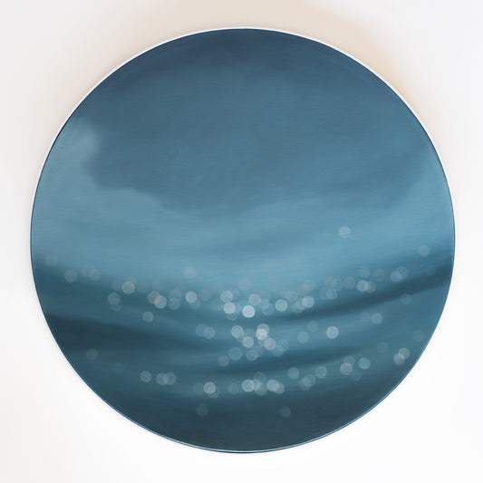 Art on round canvas framed in white, water bokeh, shimmering light on ocean or lake. Blue painting by Mel McKenzie, The Penny Drops.