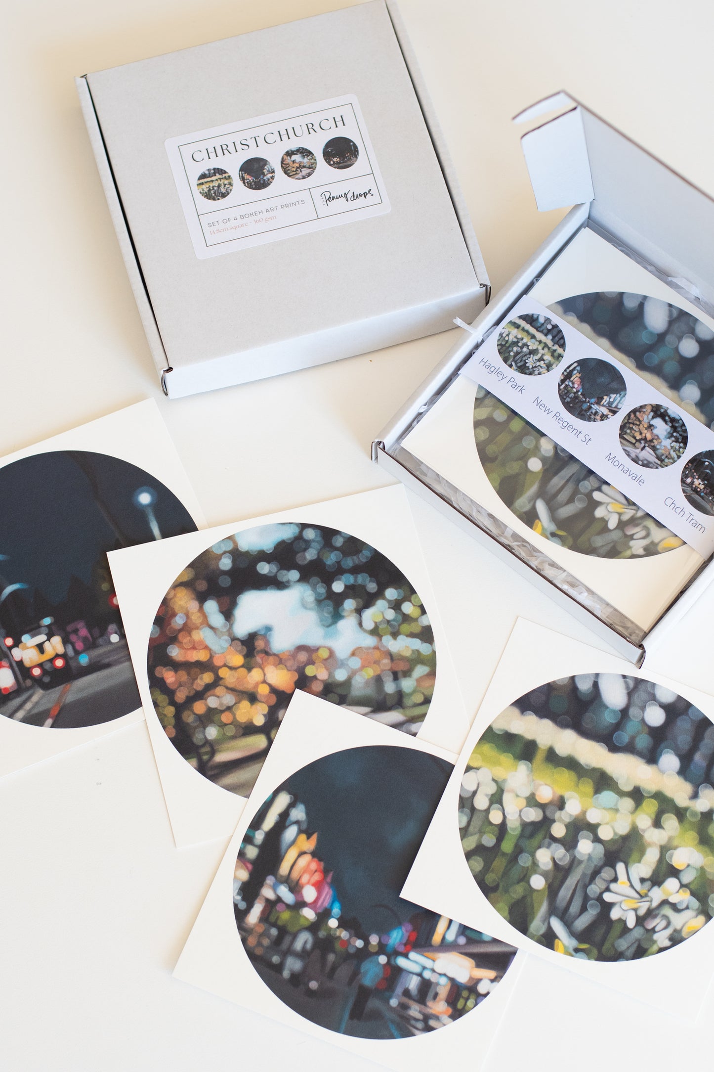 Set of circular fine art bokeh prints with Christchurch-themed packaging on a light background
