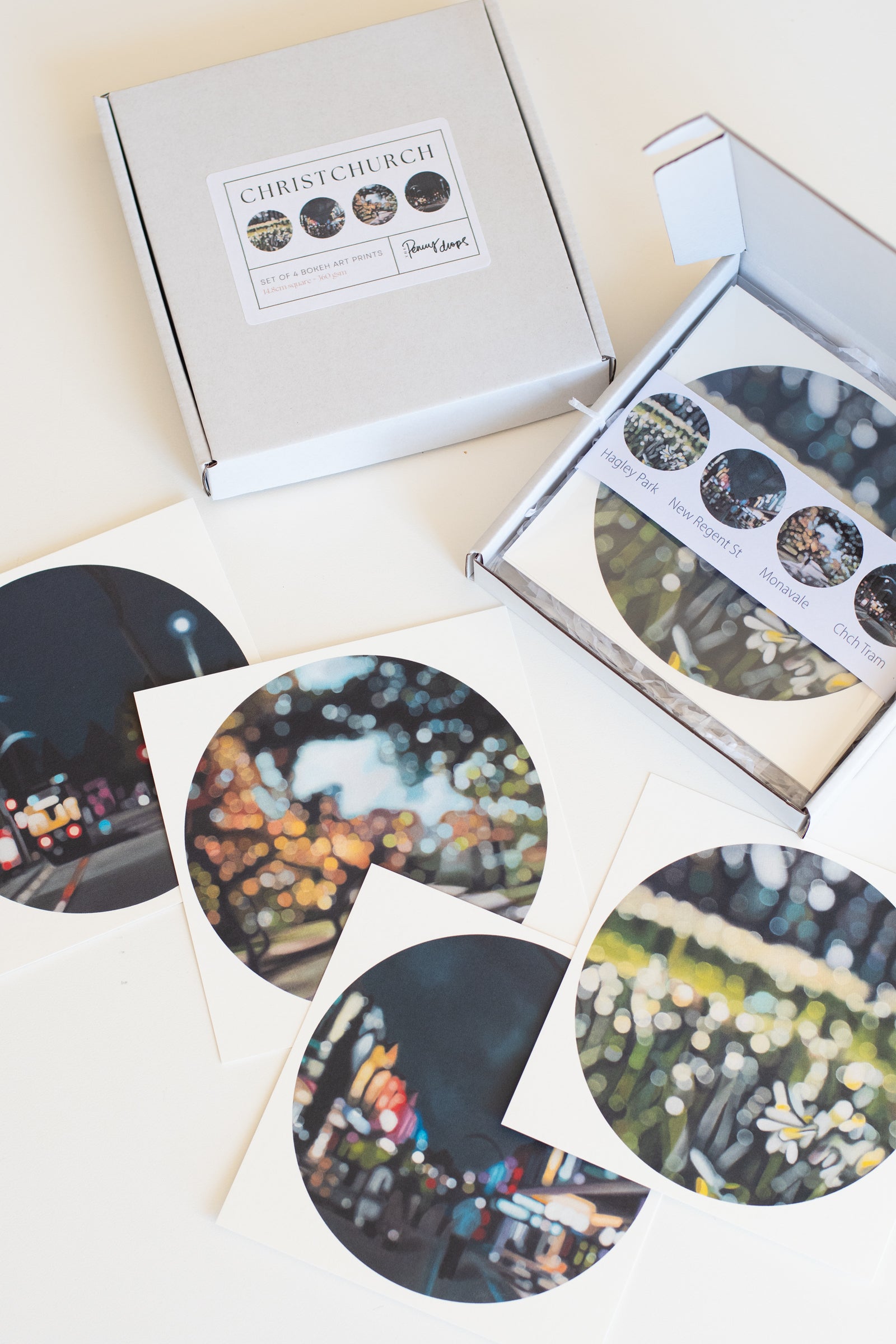 Set of circular fine art bokeh prints with Christchurch-themed packaging on a light background