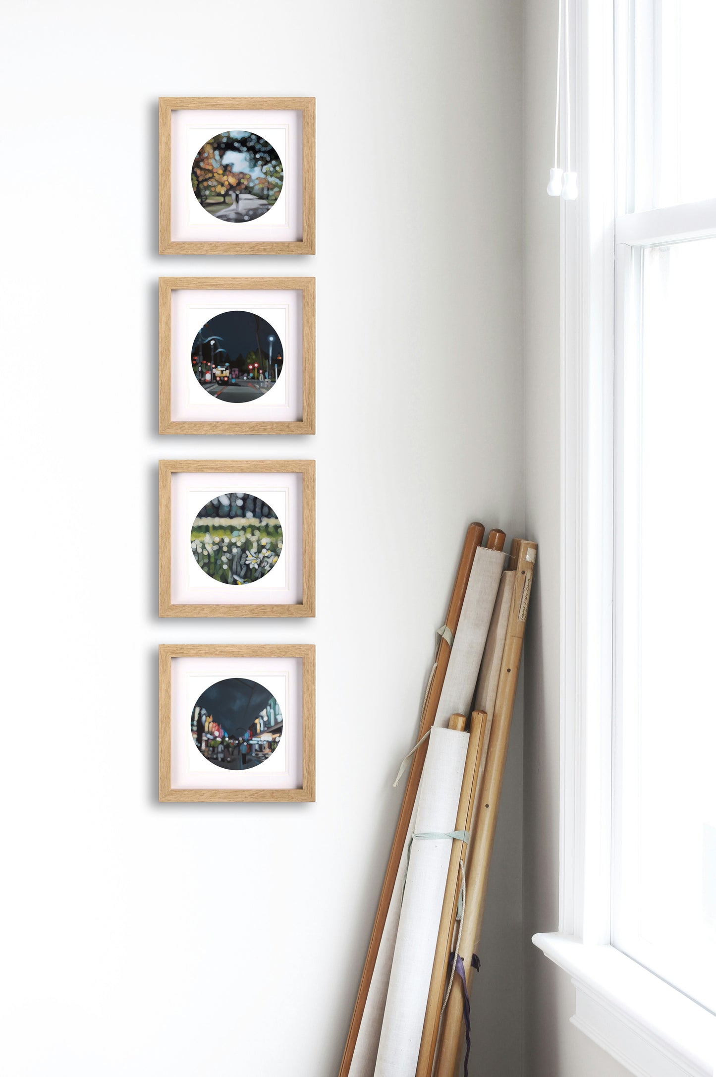 Four framed bokeh prints of Christchurch on a wall with a window.