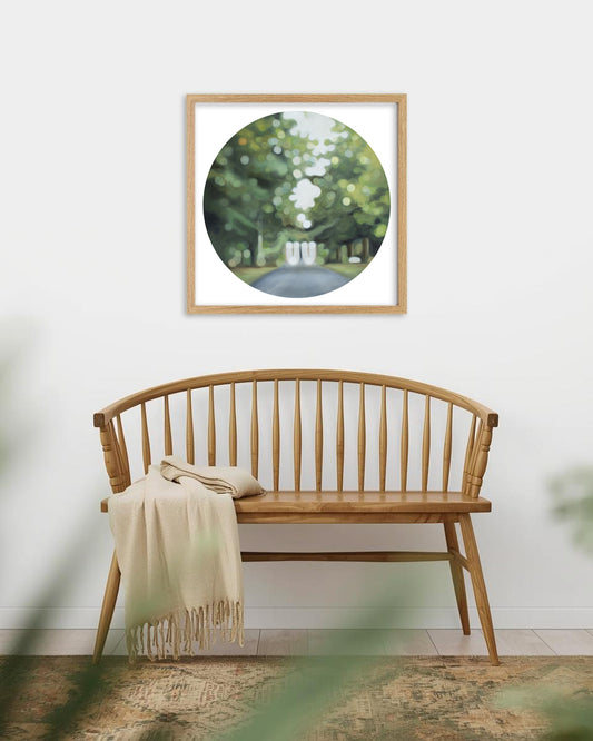 Lush green bokeh art print hangs above a wooden bench seat in a square wooden frame. The image features Invercargill's Queens Park.