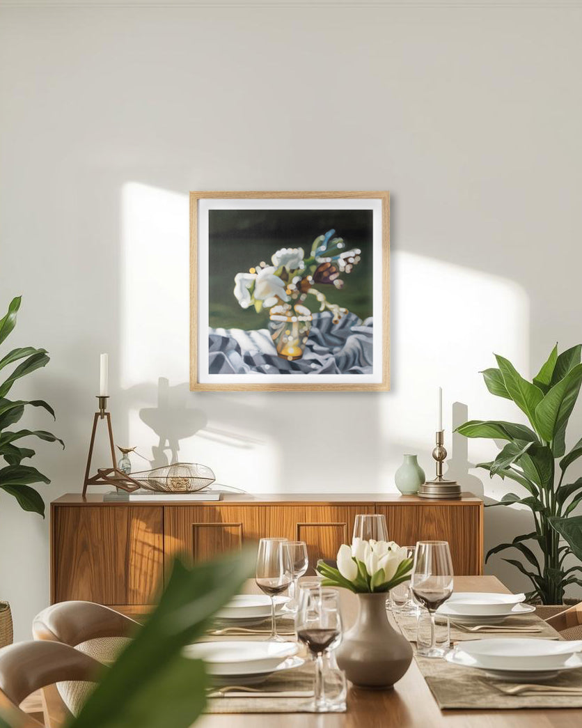 Dining room with a framed blurry bokeh still life fine art print on the wall, table set with plates and glasses, and plants.